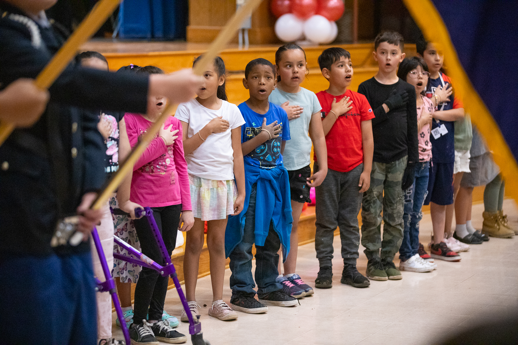 Students say the Pledge of Allegiance during an assembly