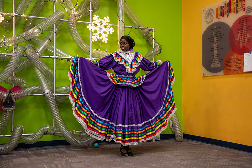 A girl dances in a purple folklorico dress
