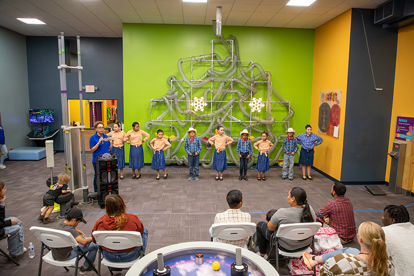 Students stand in front of an audience, waiting to perform their dance